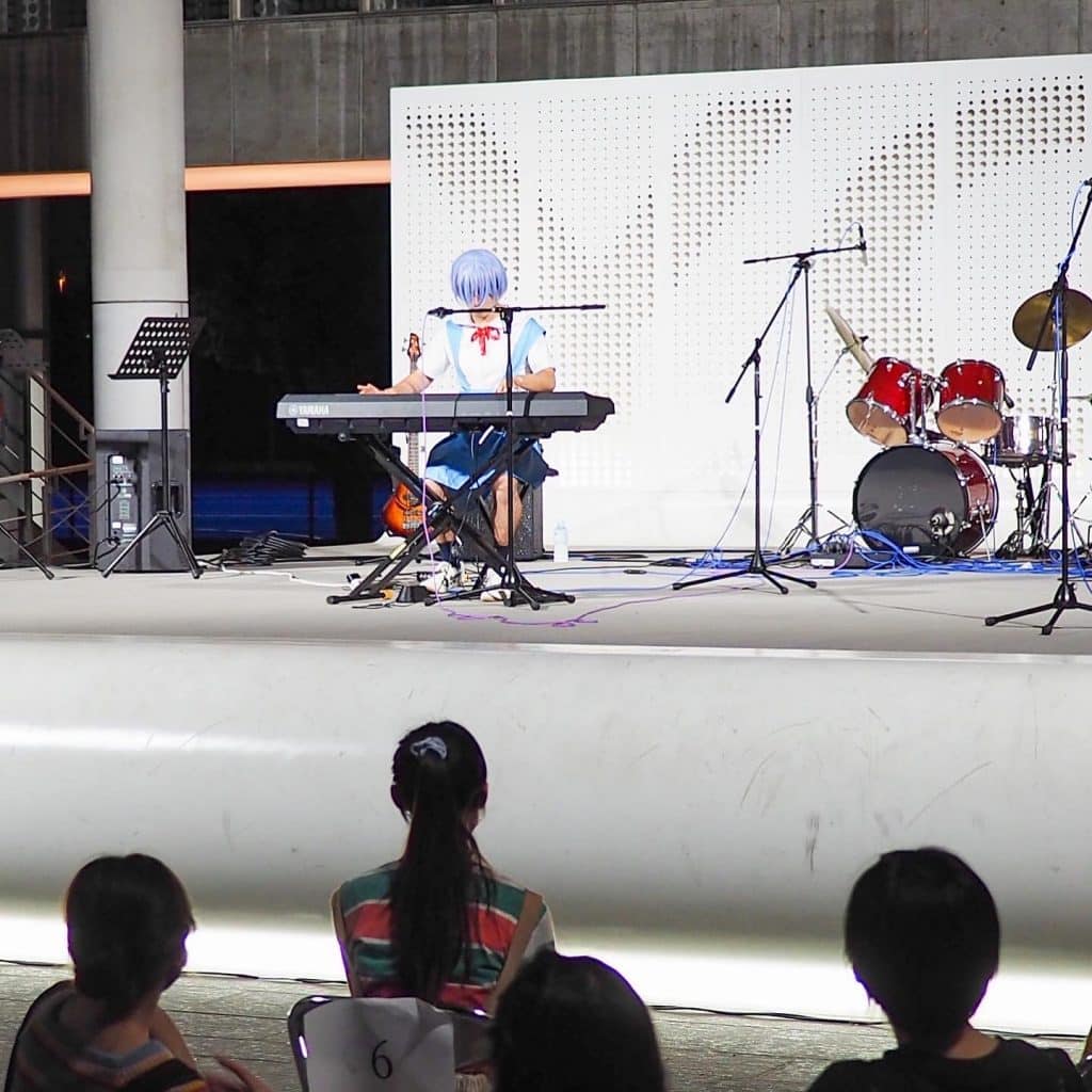 Japanese student in cosplay playing keyboard piano