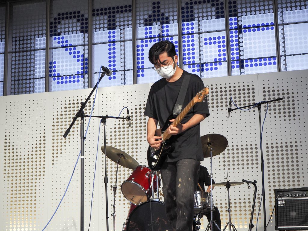 Japanese student playing guitar on stage