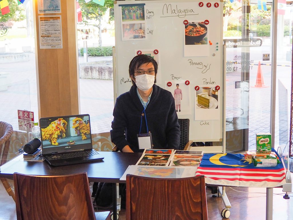 International student from Malaysia showcasing culture booth at campus event