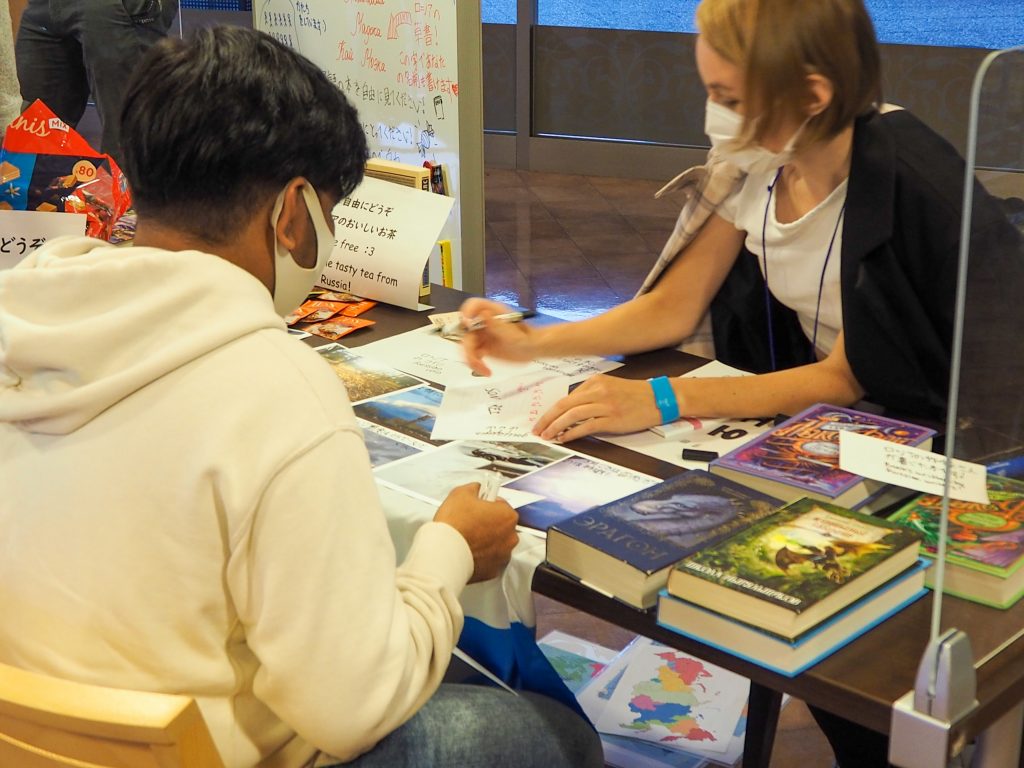 International student from Russia talking to visitors at campus event