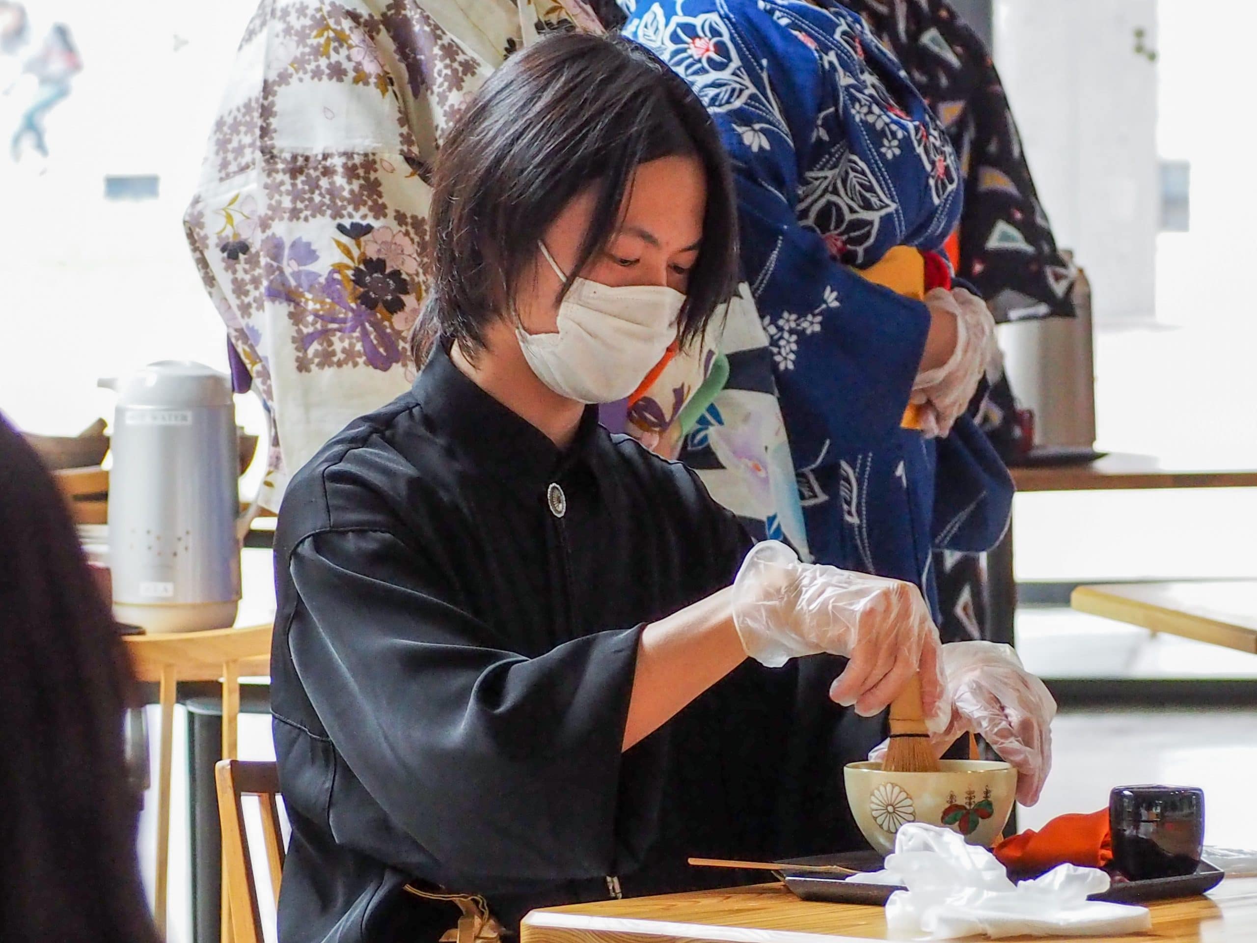 A student prepares matcha in a traditional manner