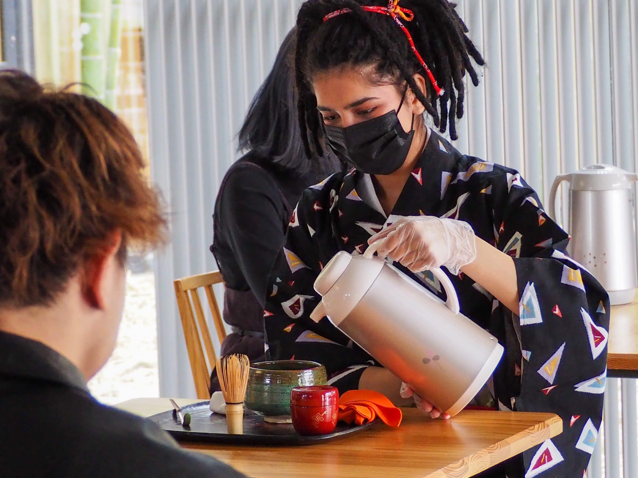 An international student pours hot water into tea cup for tea ceremony