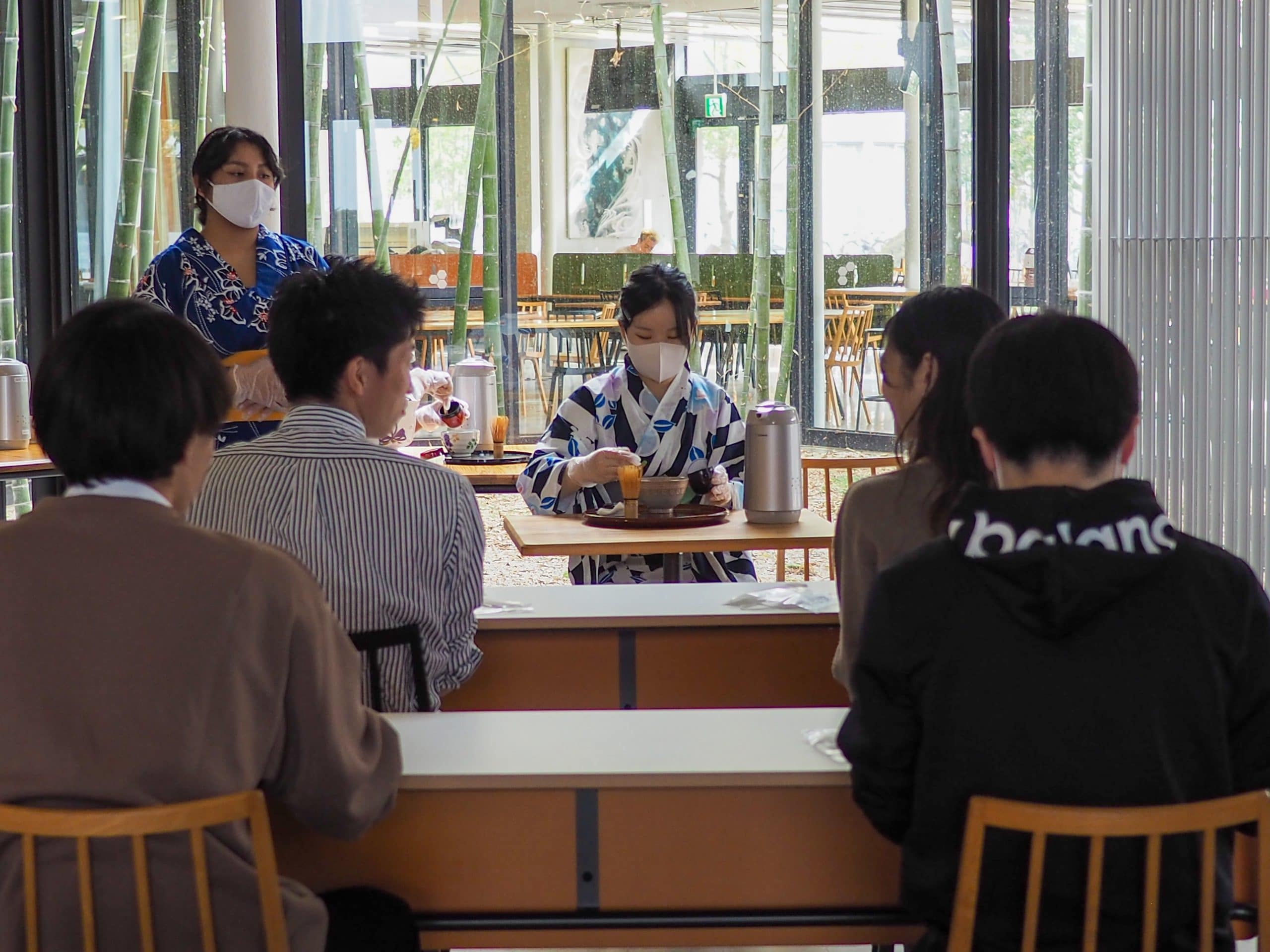 Visitors watching a student perform tea ceremony