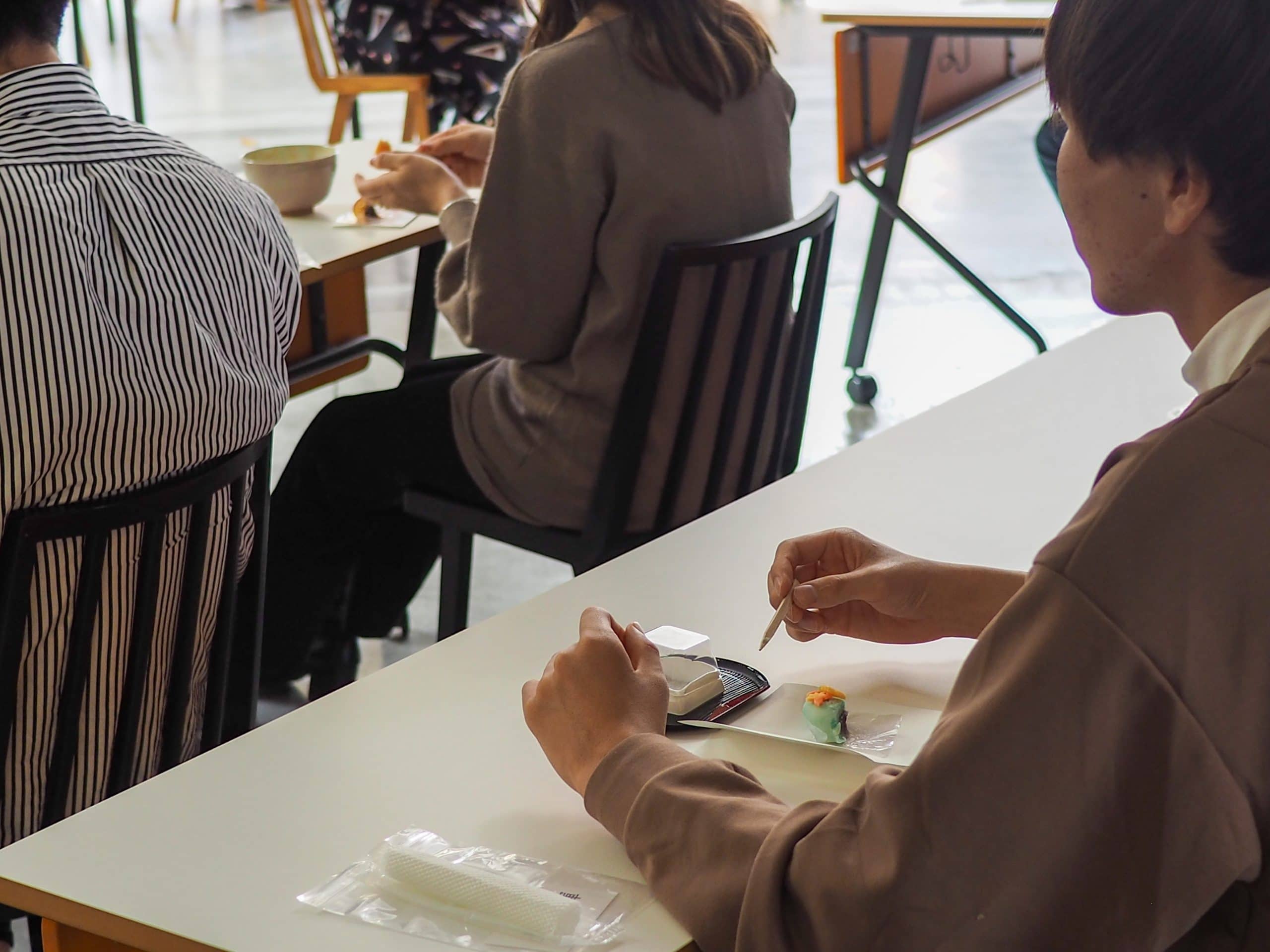 A guest enjoys a traditional Japanese sweet during iCLA's tea ceremony workshop event