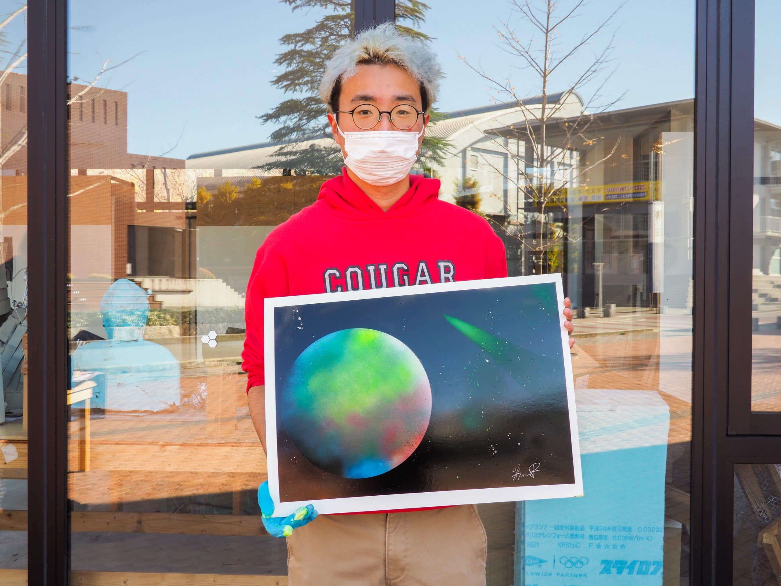 Student holding spray paint artwork