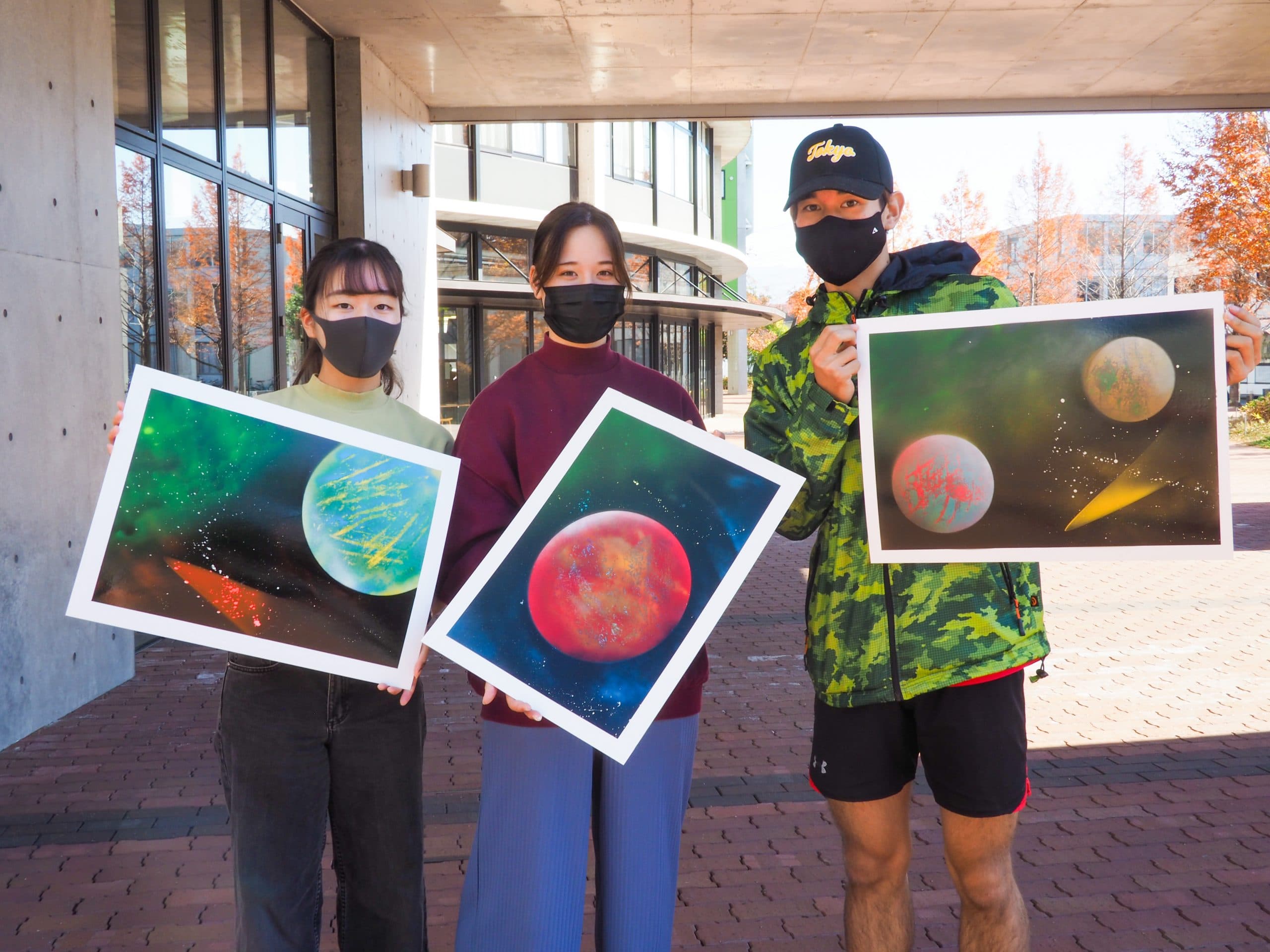 Students holding their spray paint artwork