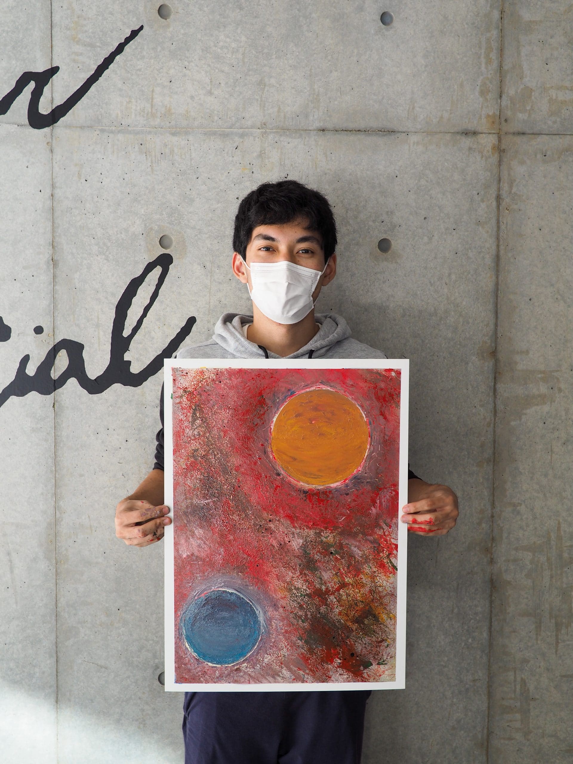 Student holding spray paint artwork