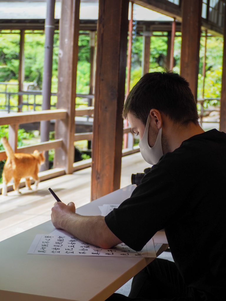 International student practices Japanese calligraphy at Erinji Temple