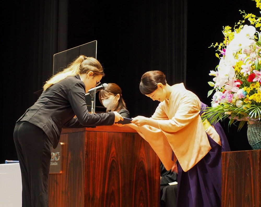 An iCLA student is conferred a diploma at the Fall 2022 Graduation Ceremony.