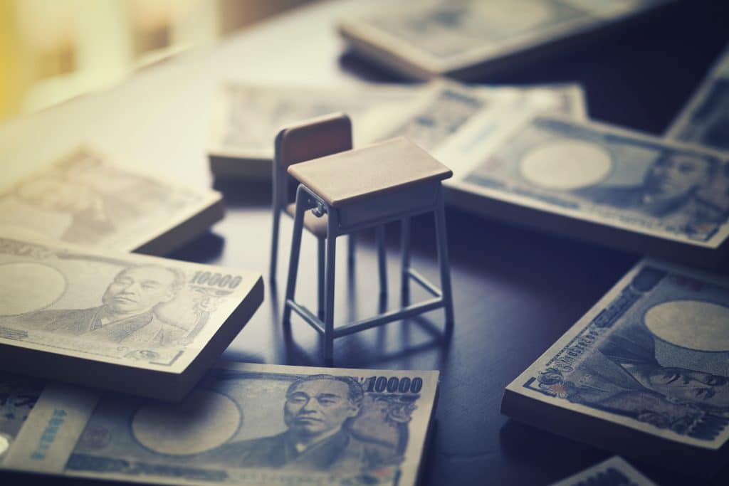 Japanese School desk surrounded by 10,000 yen notes