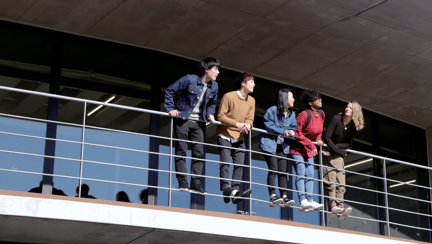 5 iCLA students hanging over a railing