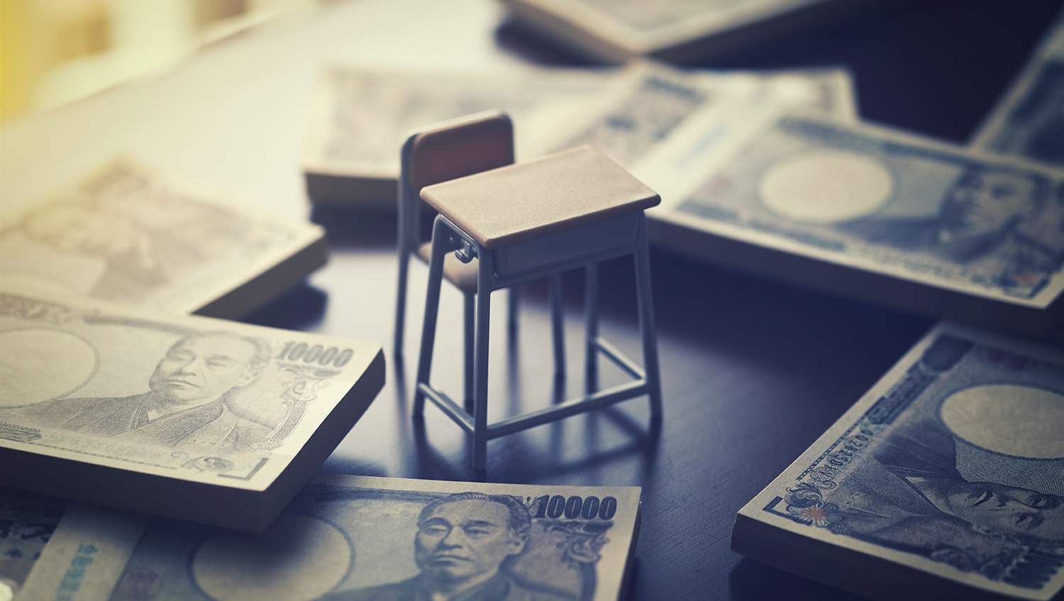 Japanese School desk surrounded by stacks of 10,000 yen notes