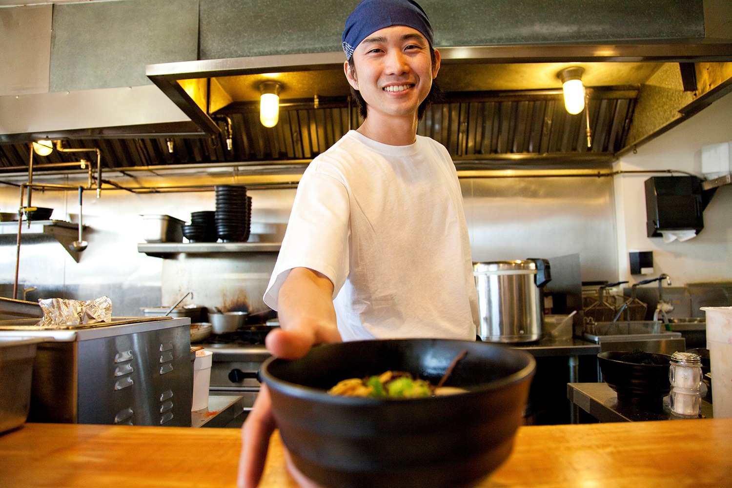 Man serving a bowl of food at a Japanese restaurant
