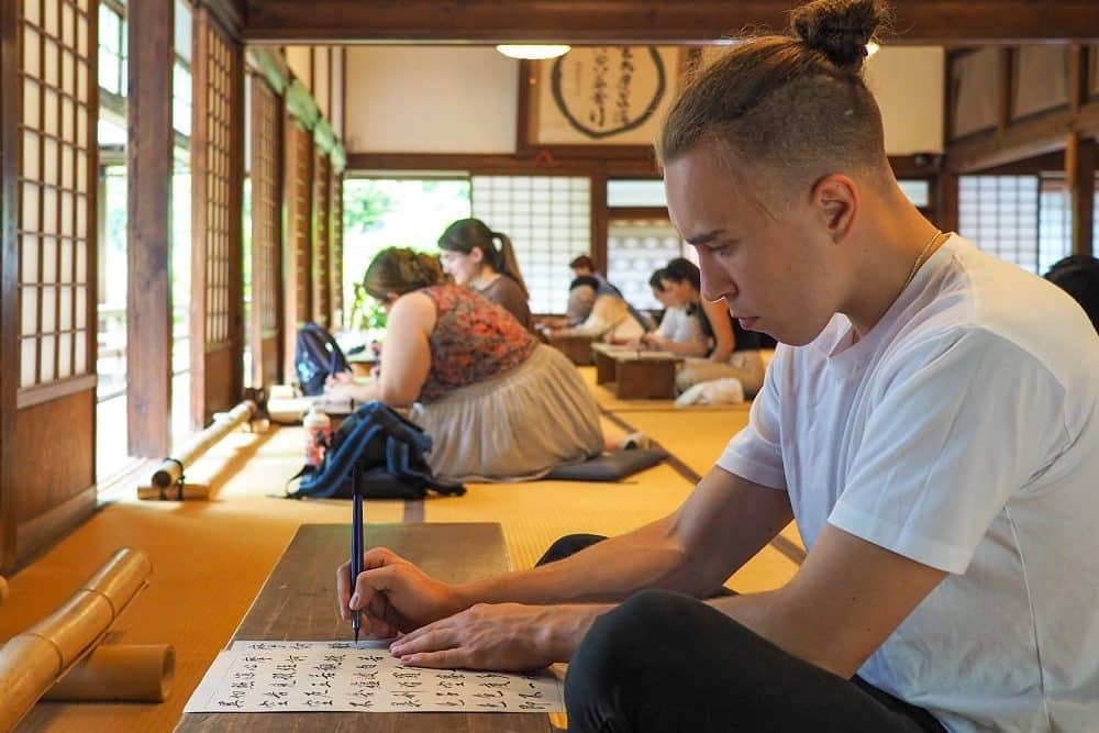 iCLA exchange student practices Japanese calligraphy at Erinji Temple