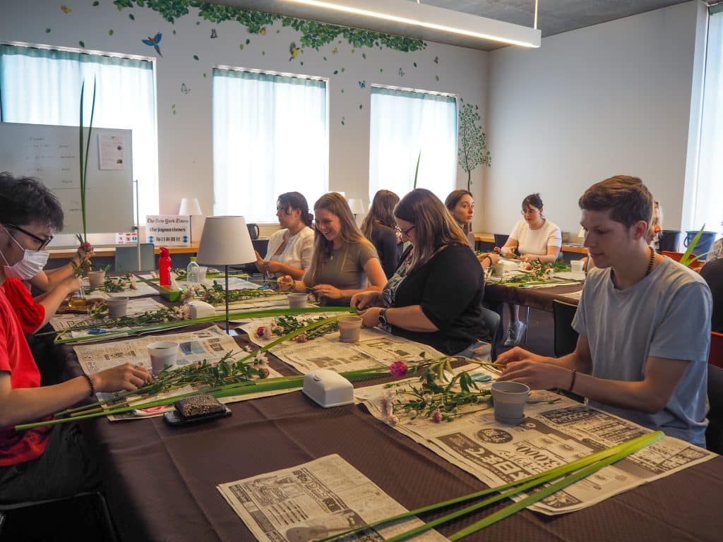 iCLA students try flower arrangement as part of the O-Chat Time events in LAC