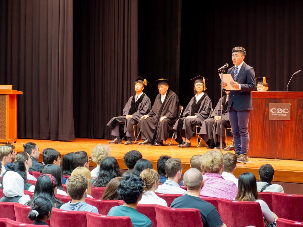 A student representative from iCLA makes a speech on the stage at the Yamanashi Gakuin University Fall 2023 Entrance Ceremony