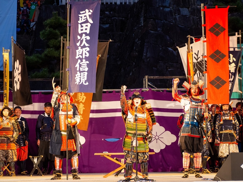 iCLA students and Professor William stand on the stage at the Shingen-ko Festival. 