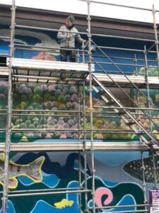 iCLA alumnus Gaku Okata works on his large scale public mural at the Somaguchi Water Purification Facility in Yamanashi City.