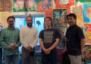 Gaku Okata standing with iCLA Professors at his solo exhibition, Cathedral. Behind them are a collection of Gaku Okata's artwork.