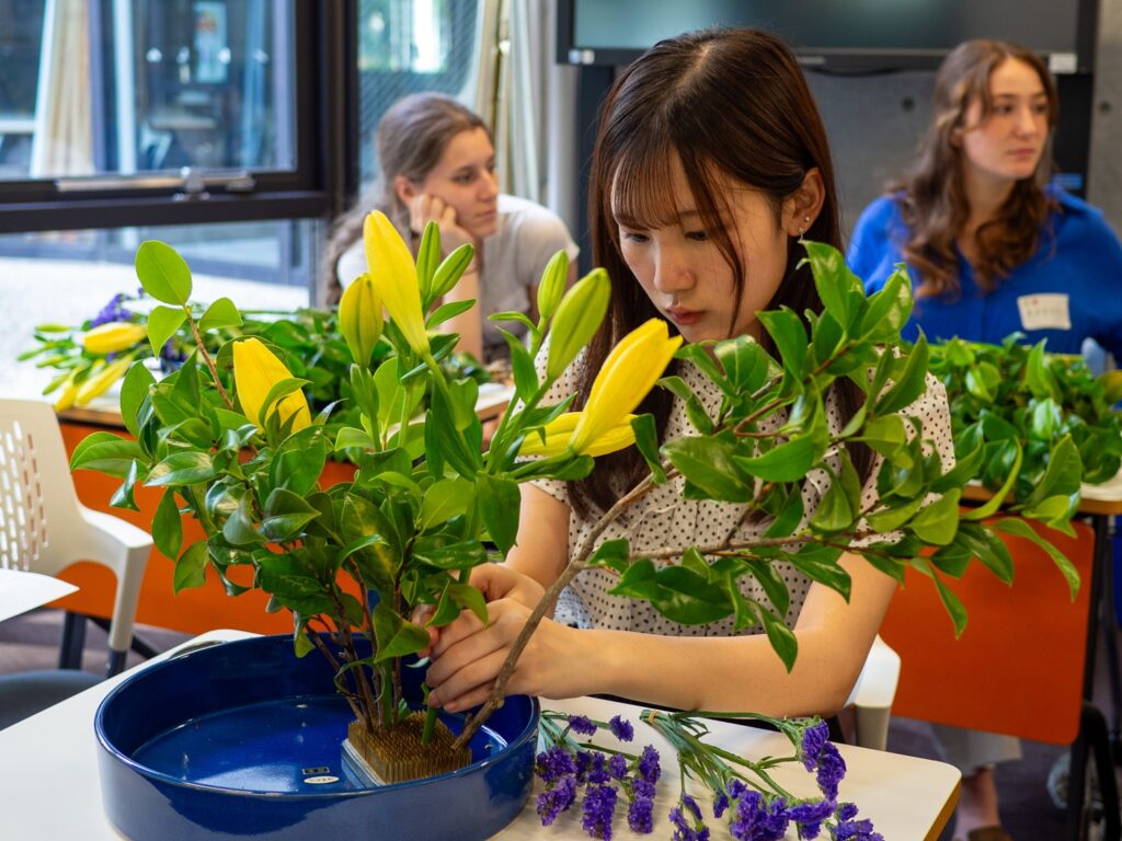 A female iCLA student is concentrated with arranging her flowers for the ikebana workshop.