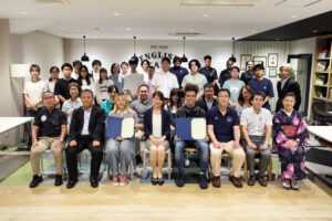 A group photo of everyone involved in the YGU Student Challenge Program, with two iCLA students whose proposals were chosen sitting at the front. The iCLA students are holding their certificate proudly.