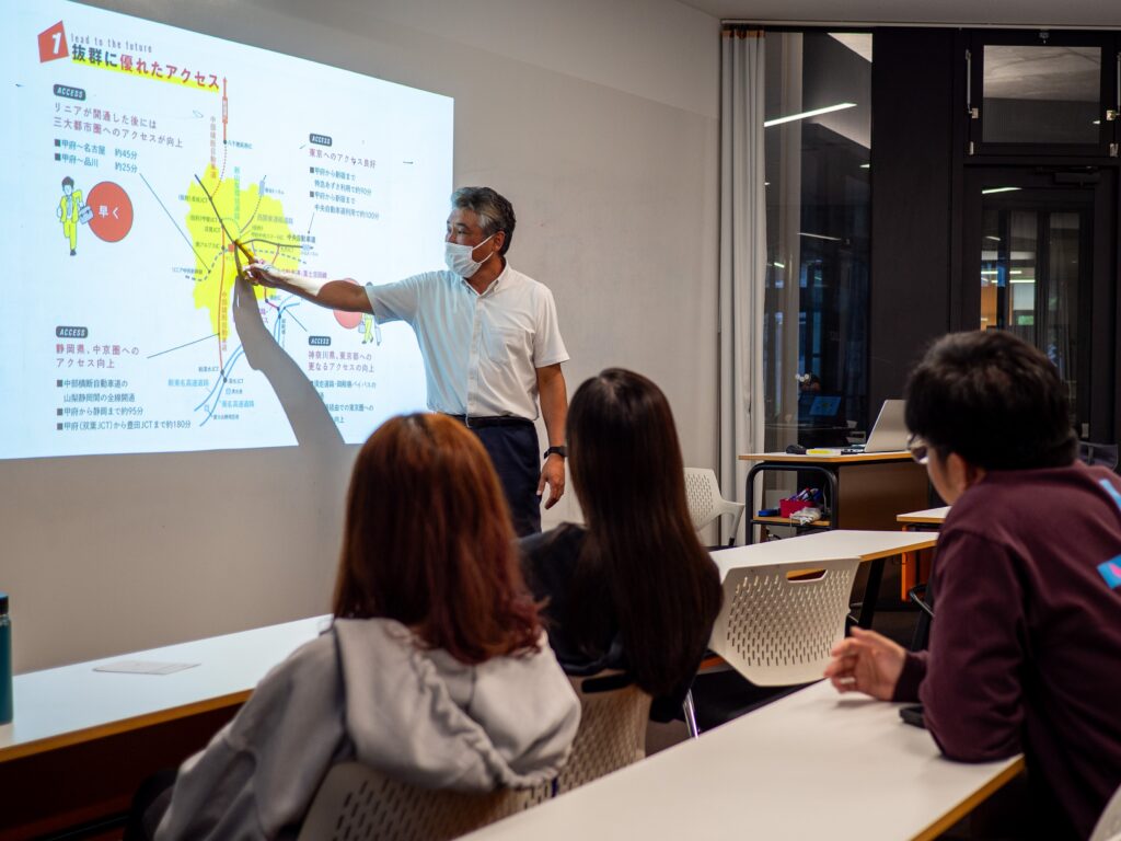 Professor Furuya of the Faculty of Business Administration explains Yamanashi's agricultural industry to a group of iCLA students in the classroom.