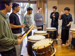 iCLA's international students try wadaiko, Japanese traditional drumming, under the tutelage of Nirasaki Kogyo High School's Taiko Club students.
