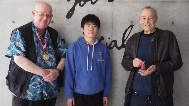 Dr. Darren Ashmore, Professor William Reed, and iCLA Alumnus Yamagishi are standing together, showing the Order of Scottish Samurai Medals.