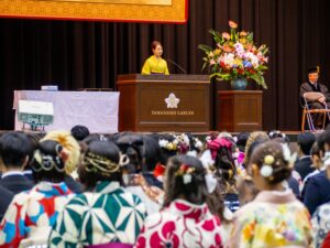 President Takako Aoyama addresses the graduating class at Yamanashi Gakuin University with a congratulatory speech.