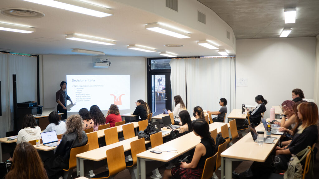 Professor Chun Yuen Terence Fong stands in front of a classroom of Psychology students, giving a talk. The talk is about Postgraduate options for Psychology.